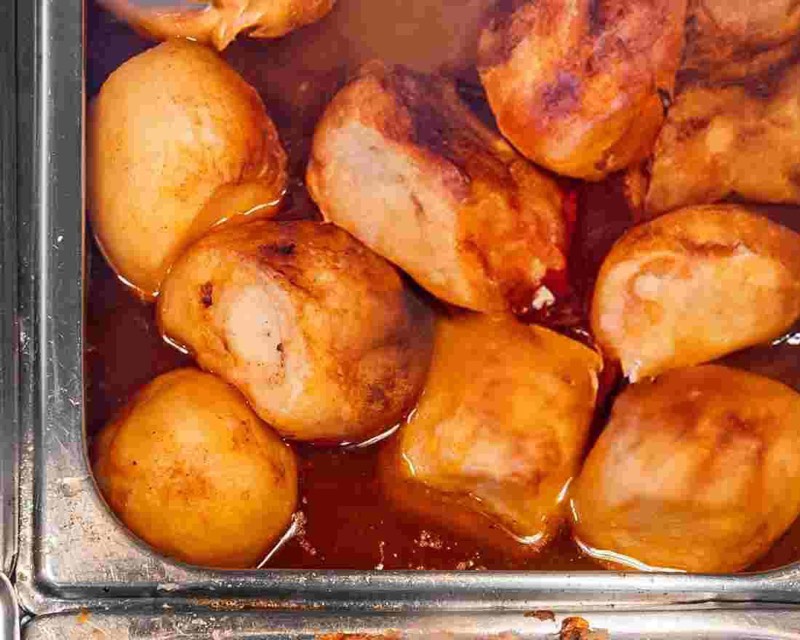 A tray of roast potatoes in gravy from the hot bar