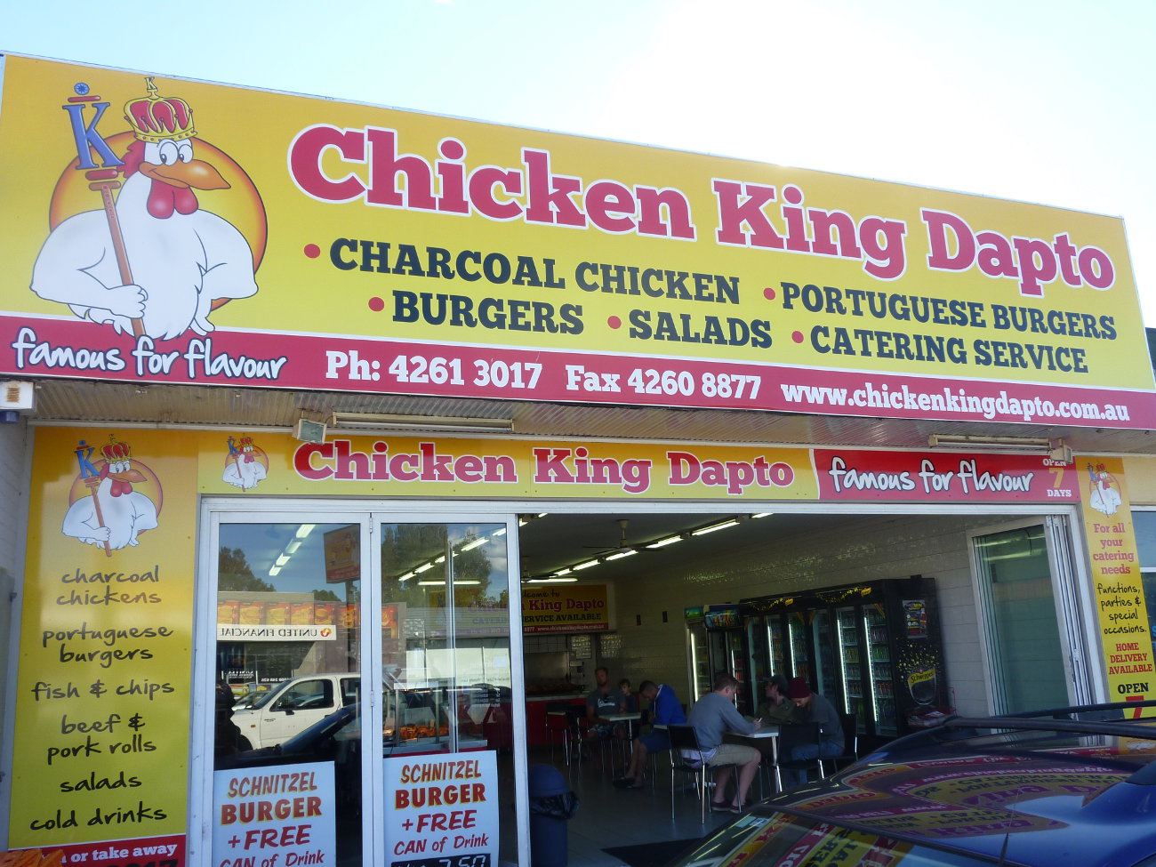 The Chicken King Dapto shopfront: a bright yellow sign over an open shop with customers eating inside